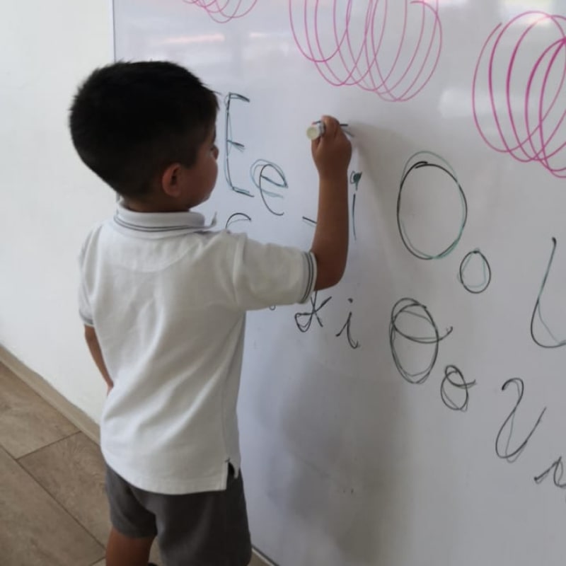 Alumno de preescolar practicando la escritura de vocales en el Instituto Cumbres Campeche
